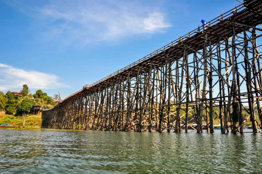 Pont en bois sur rivière sous ciel bleu