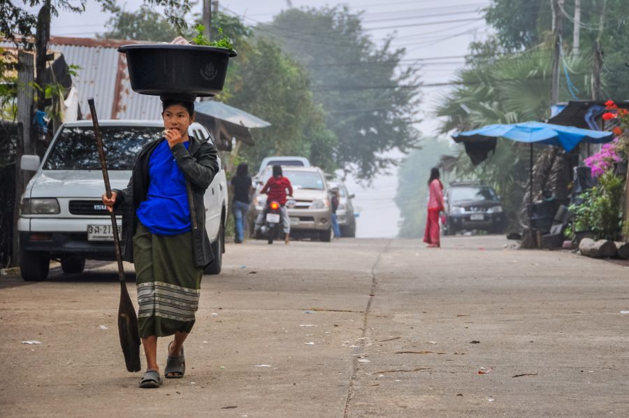 Femme portant une bassine sur la tête dans une rue