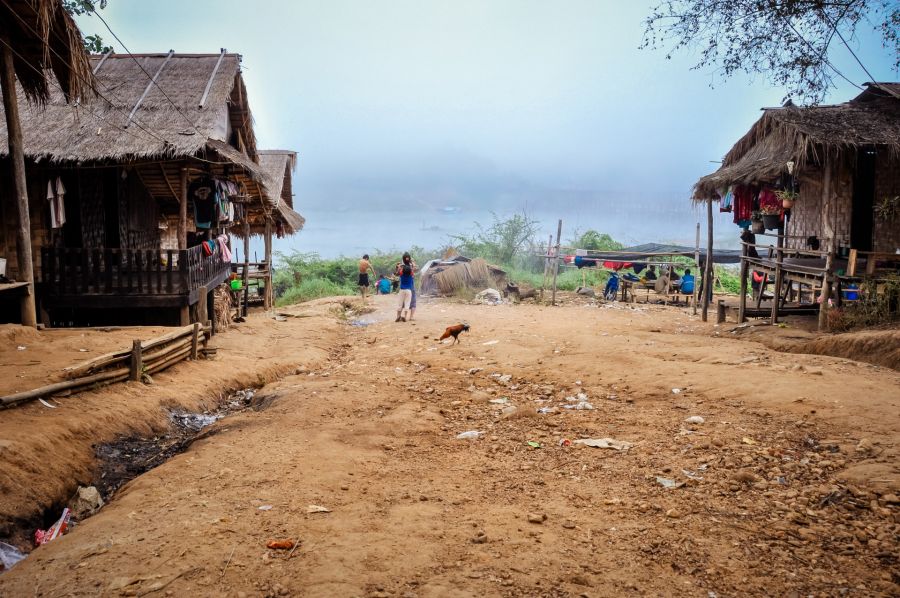 Village lacustre avec maisons sur pilotis et habitants
