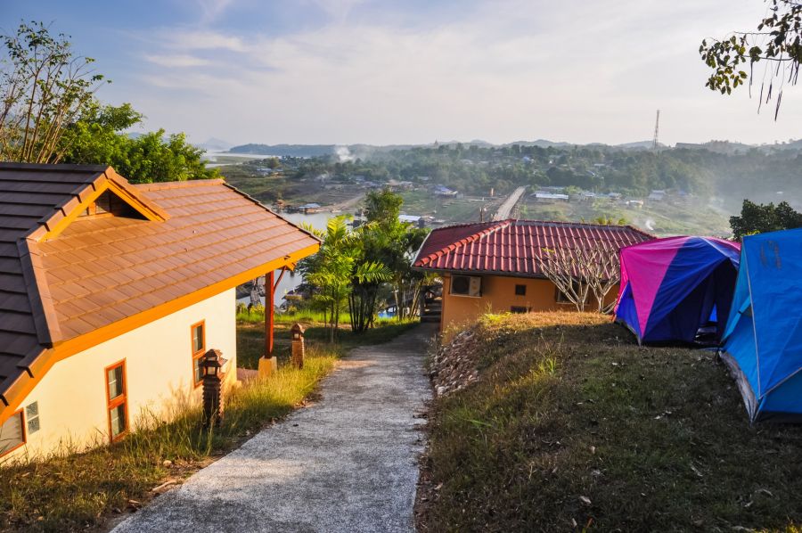 Maisons et tentes sur colline dominant village brumeux