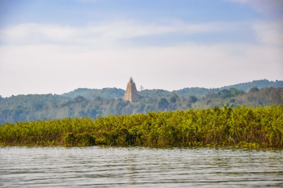 Temple hindou dominant une forêt au bord d’un lac