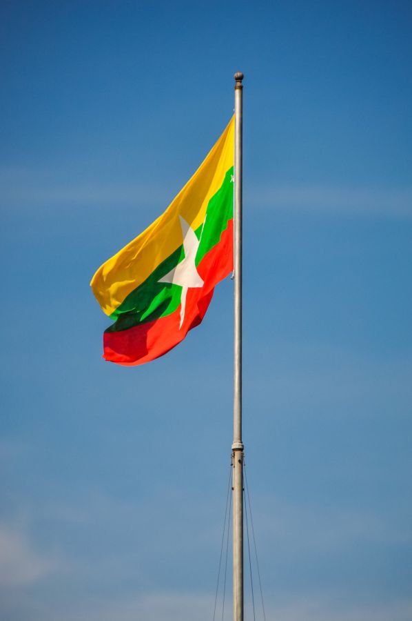 Drapeau du Myanmar flottant sur un mât sous ciel bleu