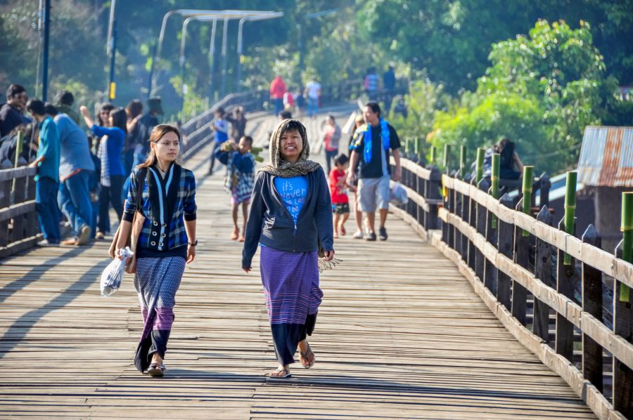 Passants traversant un pont en bois au milieu de la végétation