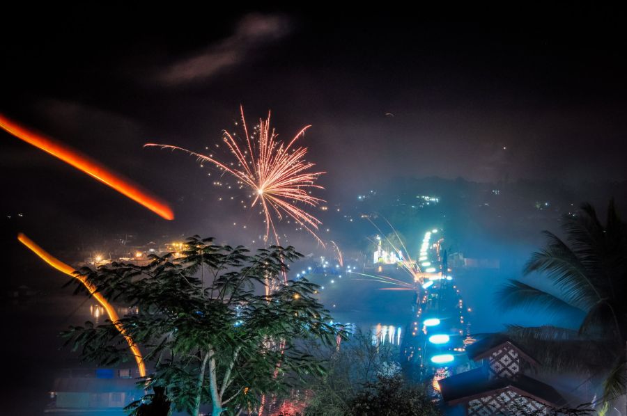 Feux d’artifice illuminant une ville tropicale la nuit