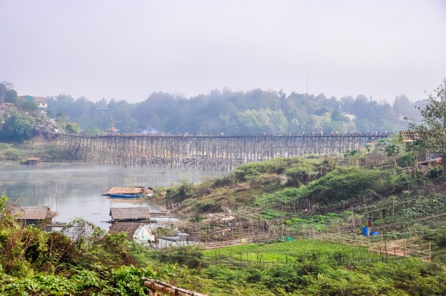 Long pont en bois sur rivière, entouré de végétation