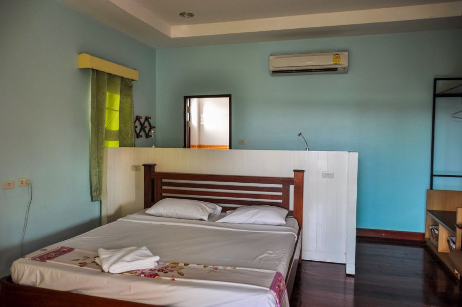 Chambre avec lit double, climatisation et murs bleus