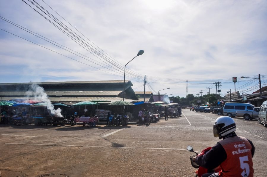 Marché de rue asiatique avec motocycliste et étals fumants