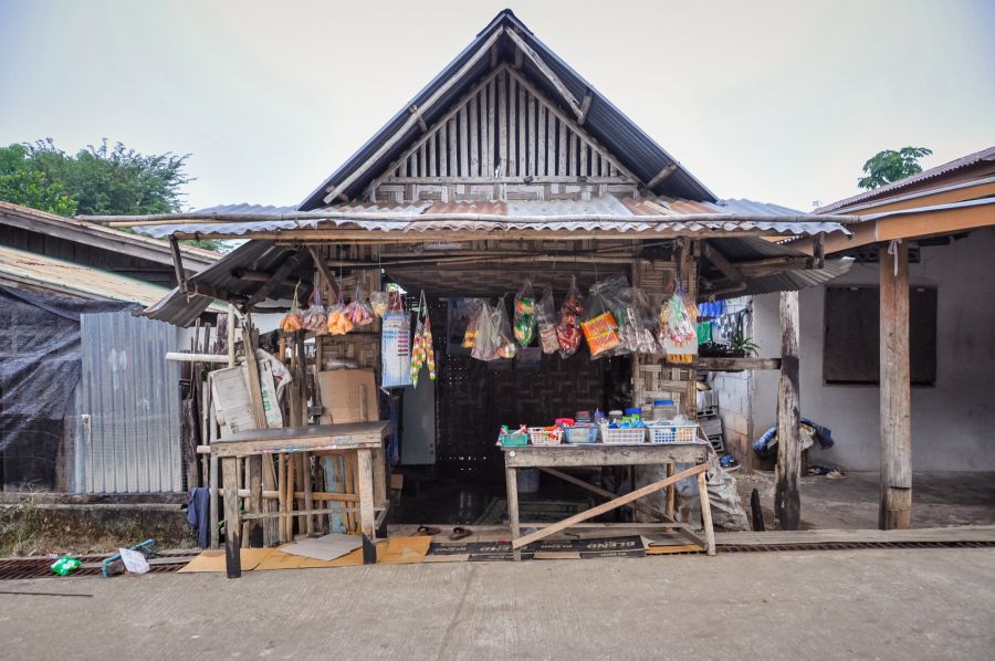 Petite épicerie rurale en bois avec produits suspendus