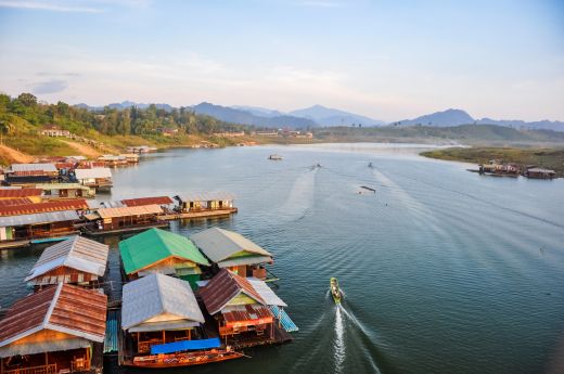 Floating village on a lake, boat and misty mountains