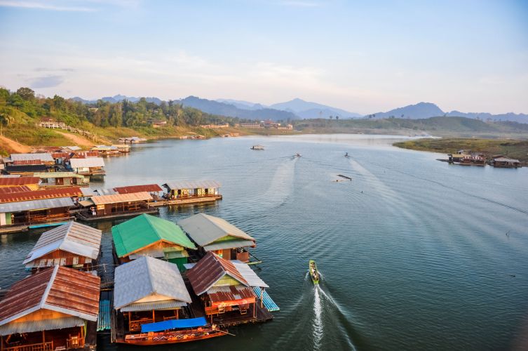 Village flottant sur lac, bateau et montagnes brumeuses