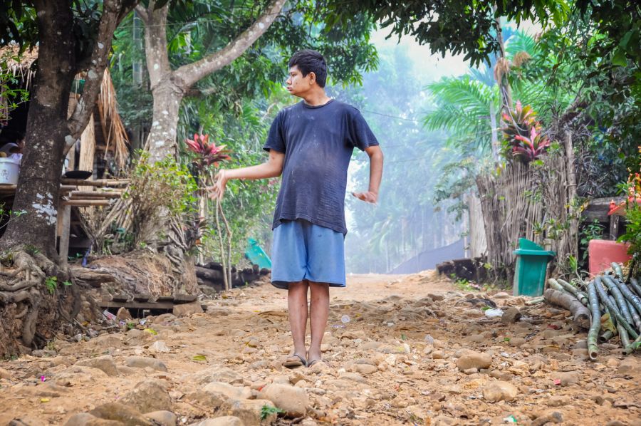 Jeune homme debout sur un chemin rural rocheux