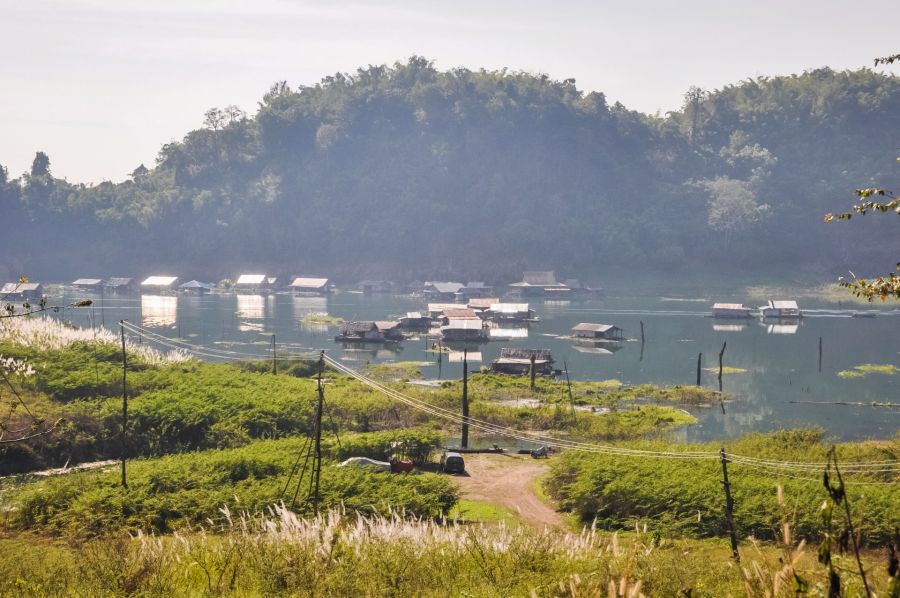 Maisons flottantes sur un lac bordé de collines boisées