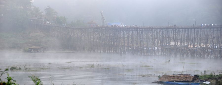 Pont en bois brumeux au-dessus d’une rivière