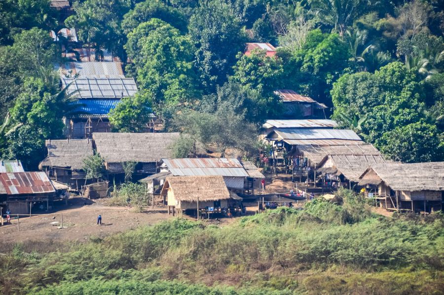 Village rural aux maisons en bambou entouré de végétation tropicale