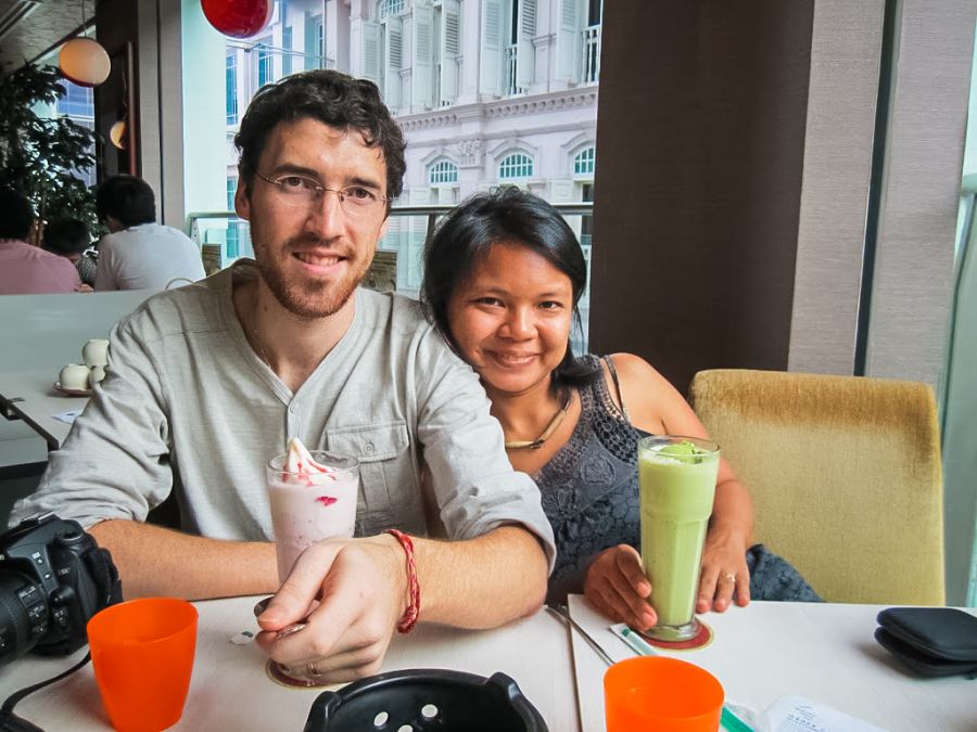 Couple souriant attablé avec boissons dans un café
