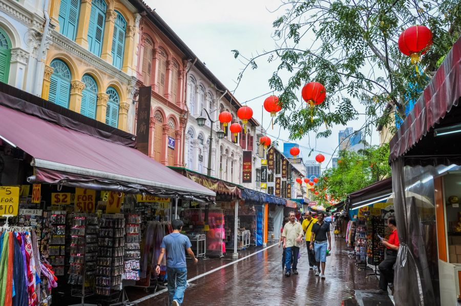 Rue commerçante animée décorée de lanternes rouges sous la pluie