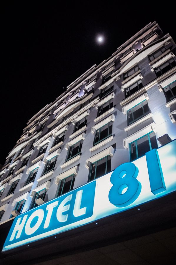 Façade nocturne éclairée de l'hôtel 81 sous la lune