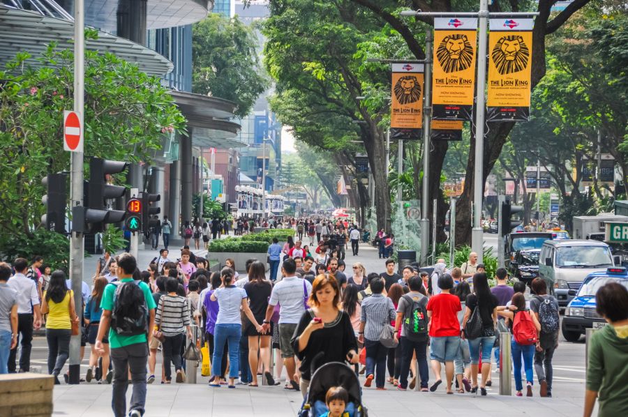 Foule dans une rue de Singapour, affiches du Roi Lion