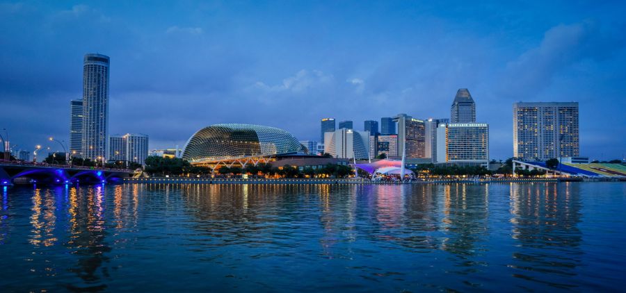 Skyline de Singapour illuminé au crépuscule, reflet sur la baie