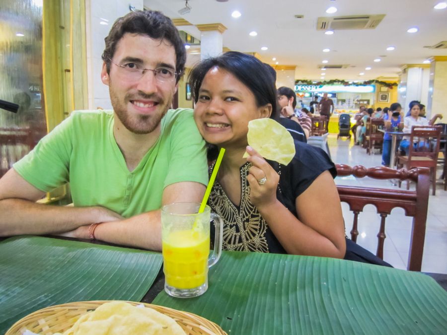 Couple souriant au restaurant avec chips et boisson jaune