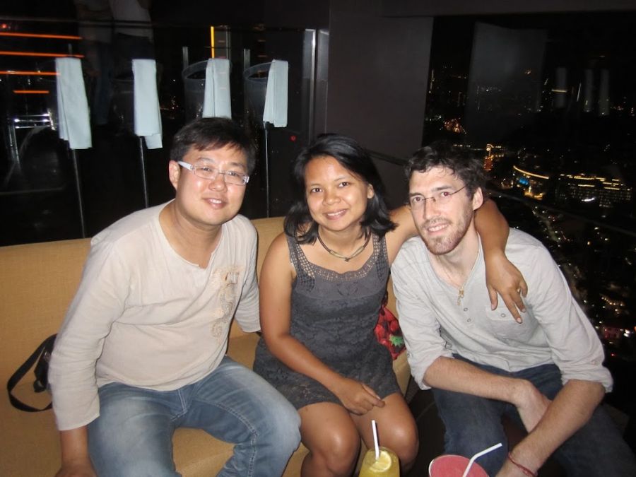 Trois amis assis ensemble devant une vue nocturne urbaine.