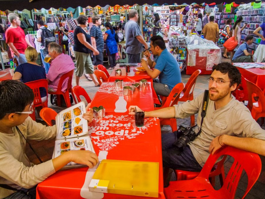 Restaurant animé dans un marché couvert avec tables rouges