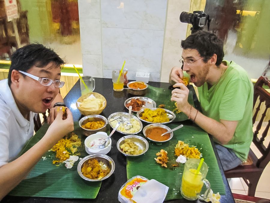 Deux hommes dégustent un repas indien sur feuilles de bananier.