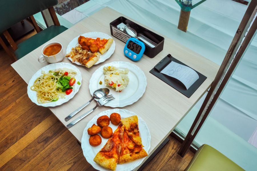 Table de restaurant avec assiettes de pâtes, pizza et plats variés