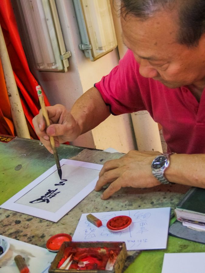 Homme pratiquant la calligraphie chinoise au pinceau