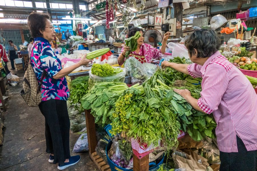 Femmes achetant des légumes frais dans un marché couvert