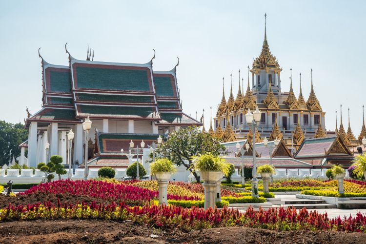 Temple thaïlandais orné de jardins fleuris et toits colorés