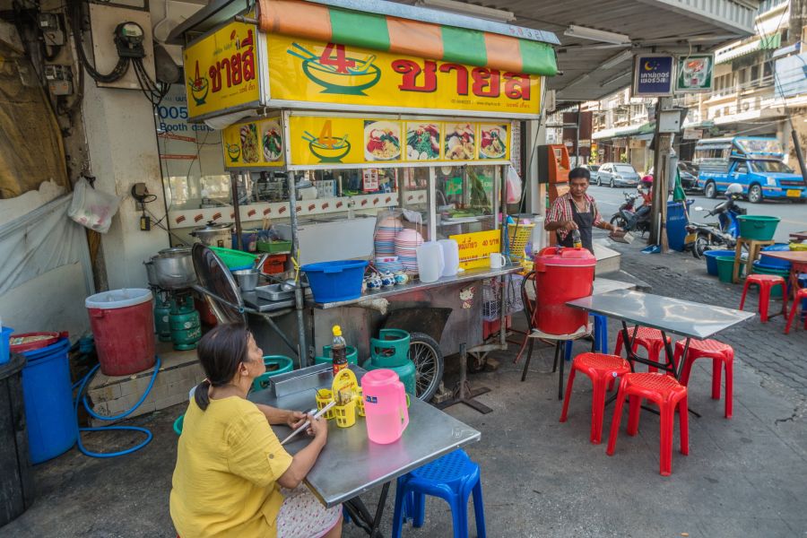 Stand de nouilles de rue avec tables à Bangkok