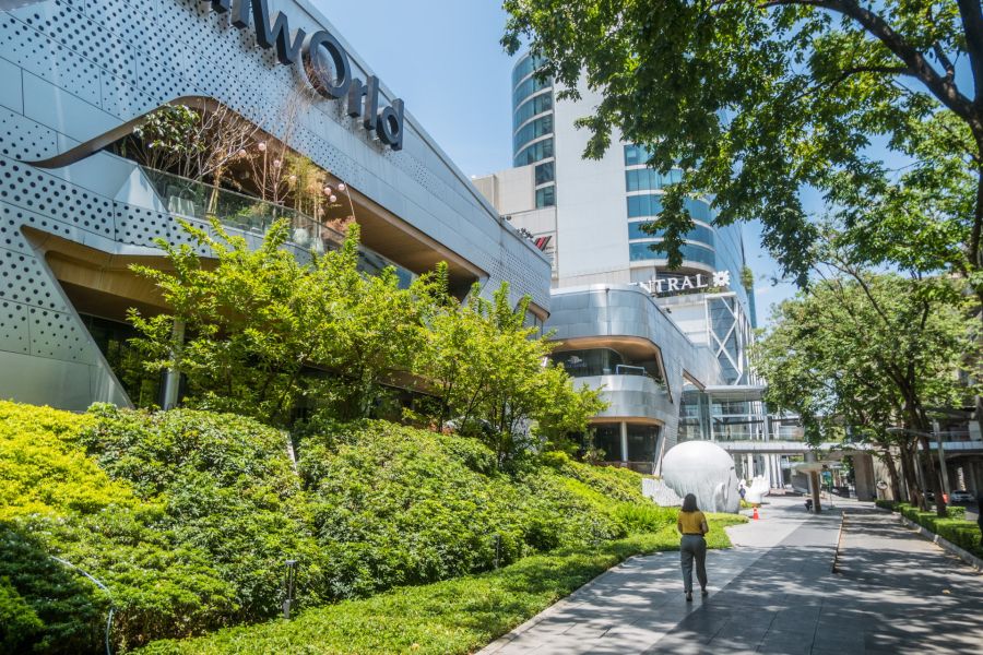 Centre commercial moderne entouré de verdure et d’immeubles