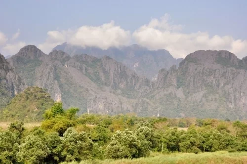 Last looks at the cliffs of Vang Vieng, tuk-tuk to the station and a slightly chaotic bus: the story of our return to Vientiane.