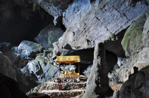 A Buddha sits in the middle of this imposing cave.