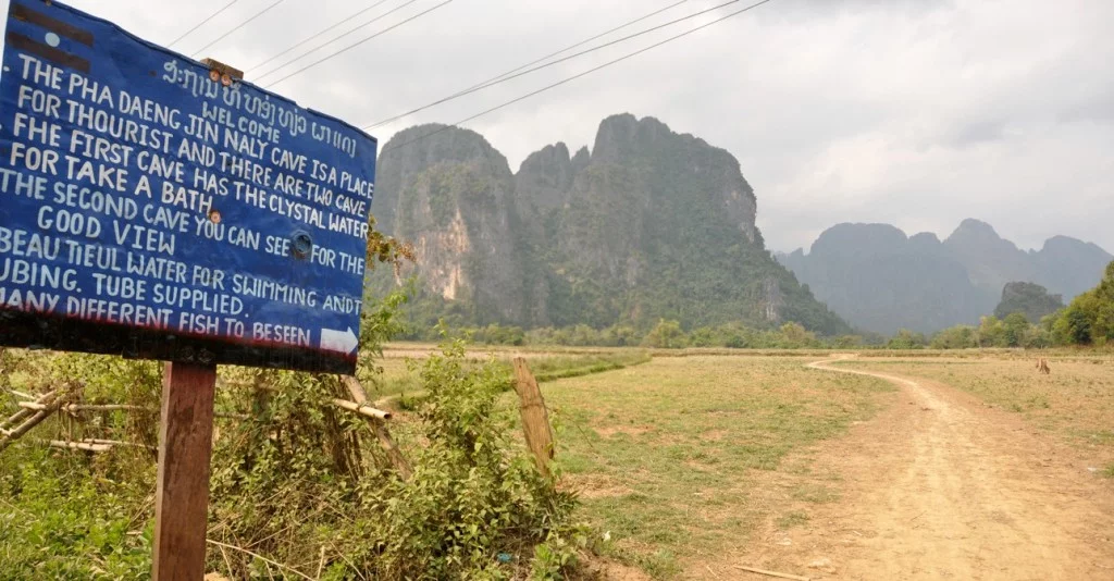 sign indicating a cave in vang vieng