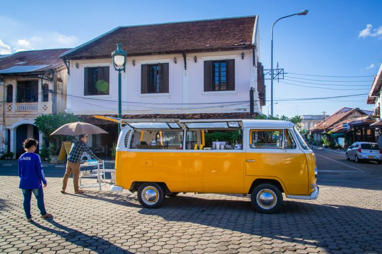 van jaune sur une place de savannakhet laos