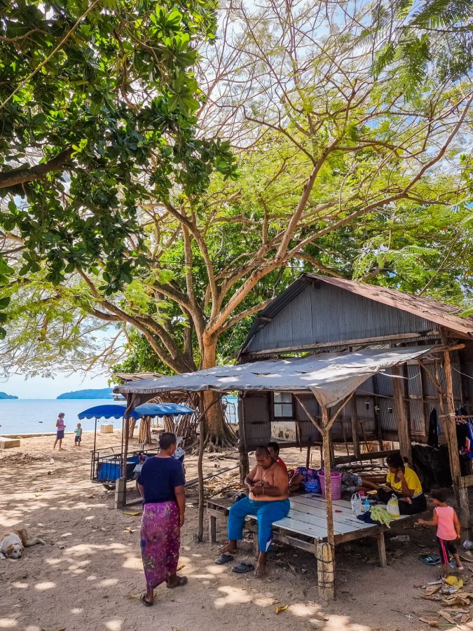 Famille devant une maison sur une plage tropicale