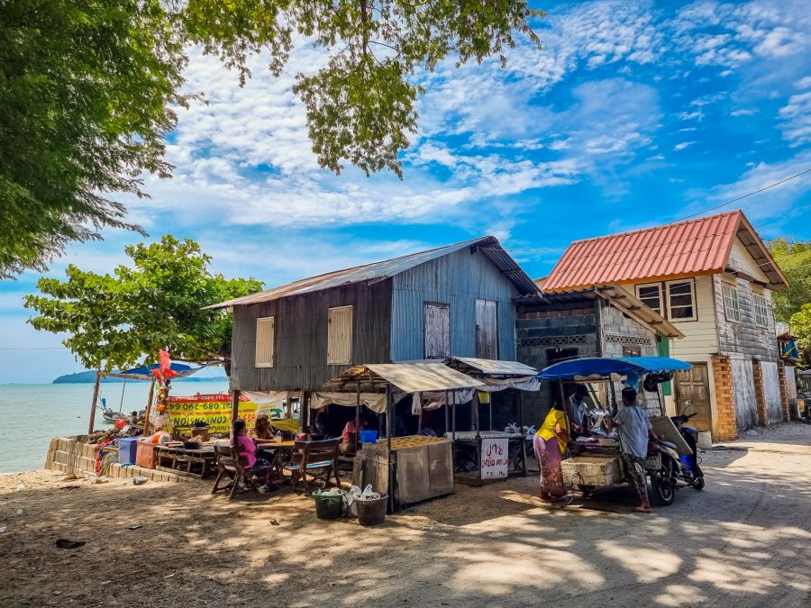 Maisons et étals en bord de mer sous ciel bleu