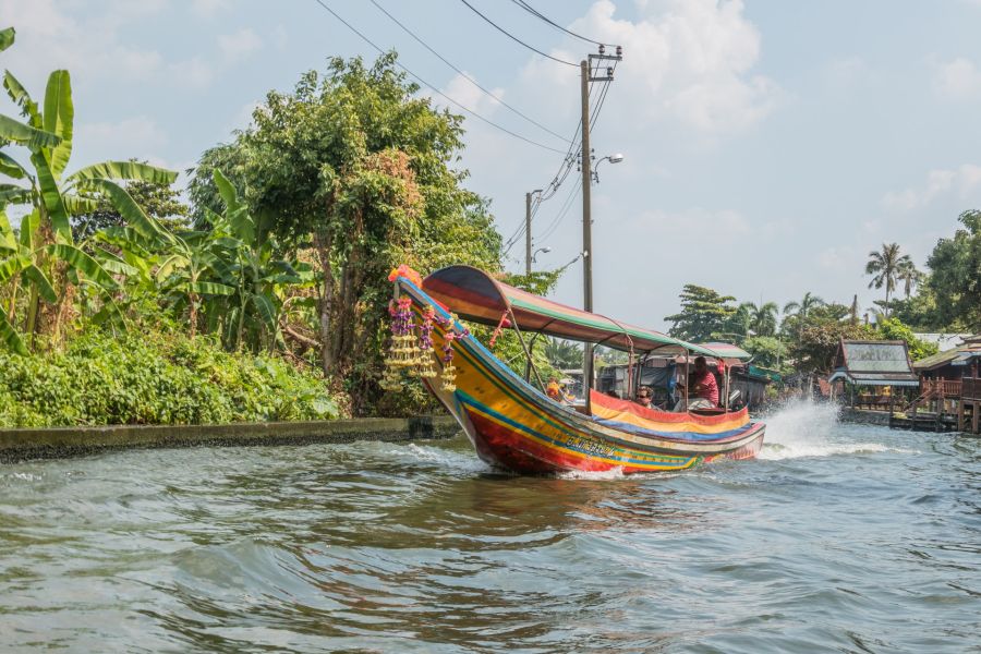 Bateau coloré naviguant sur un canal tropical thaïlandais
