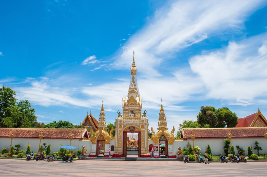 Entrée dorée d’un temple bouddhiste sous ciel bleu