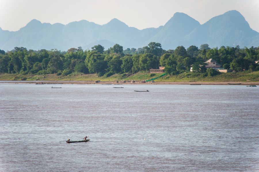 Pirogues sur le fleuve devant des montagnes verdoyantes