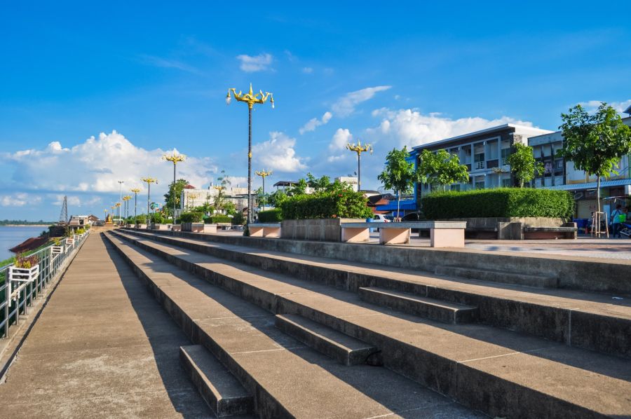 Promenade fluviale avec escaliers, lampadaires dorés et ciel bleu
