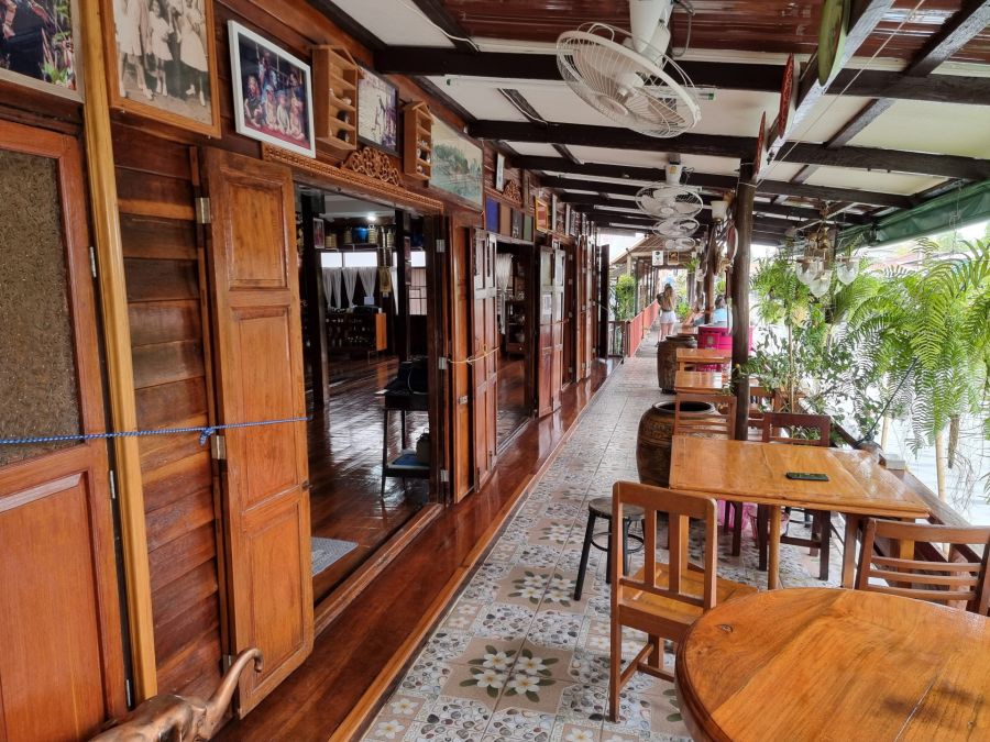 Terrasse en bois avec tables, ventilateurs et plantes tropicales