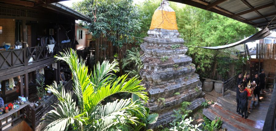 Stupa ancien entouré de végétation dans une cour traditionnelle