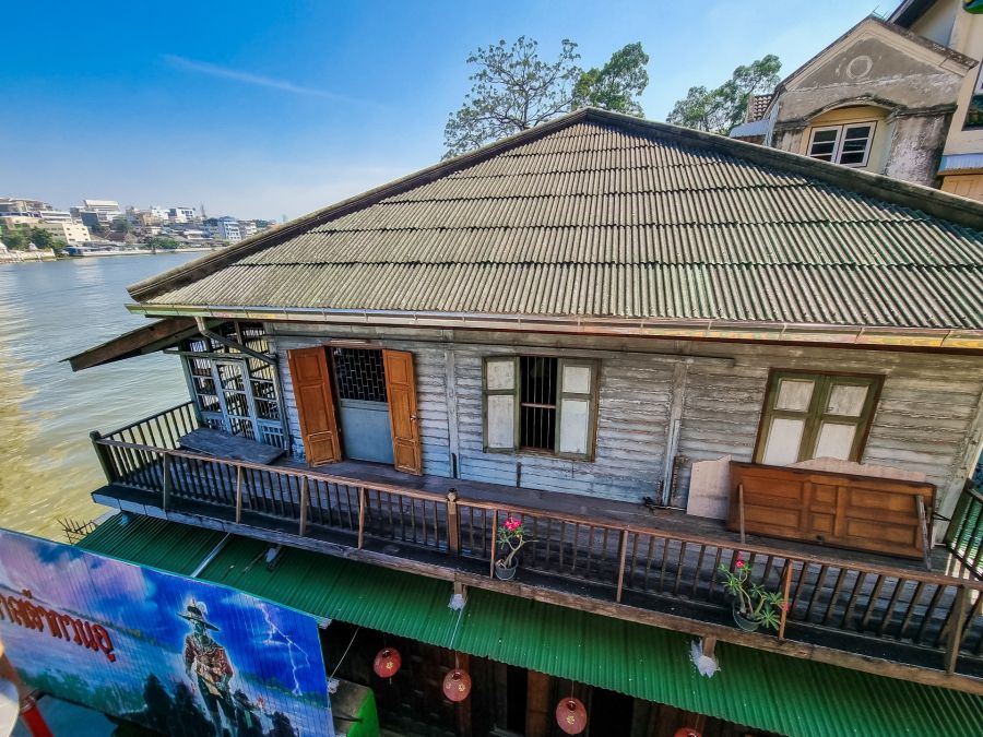 Maison traditionnelle en bois au bord d’un fleuve urbain