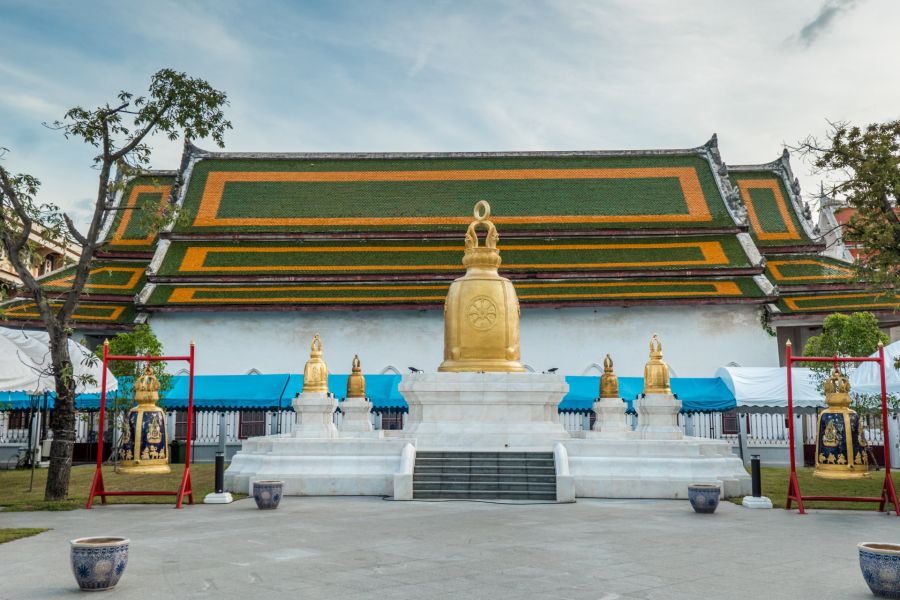 Temple bouddhiste thaïlandais avec statues dorées et toit décoré
