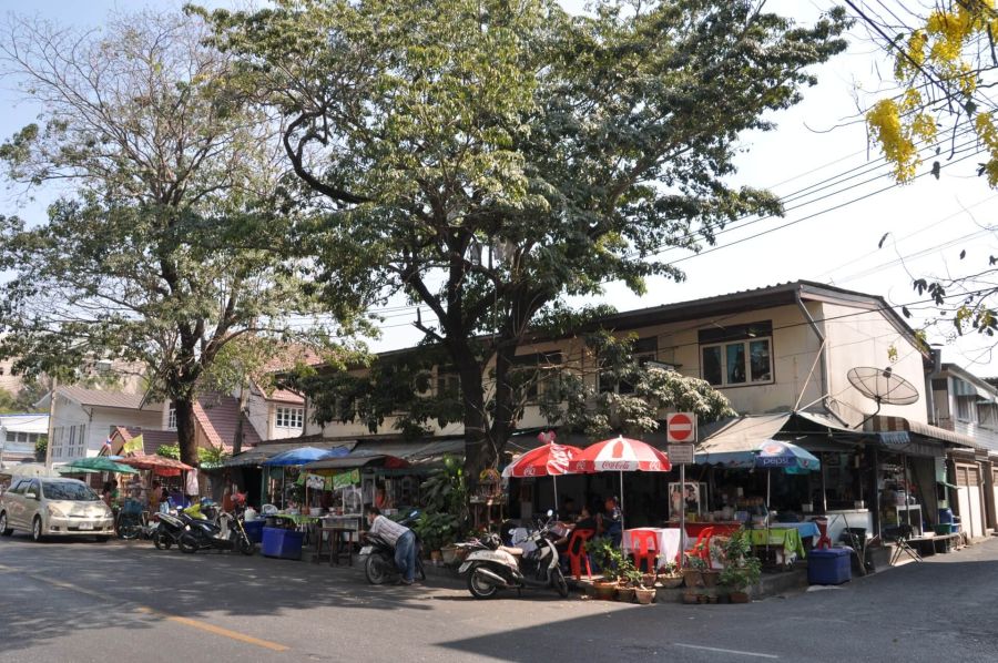 Restaurant de rue ombragé avec scooters et parasols