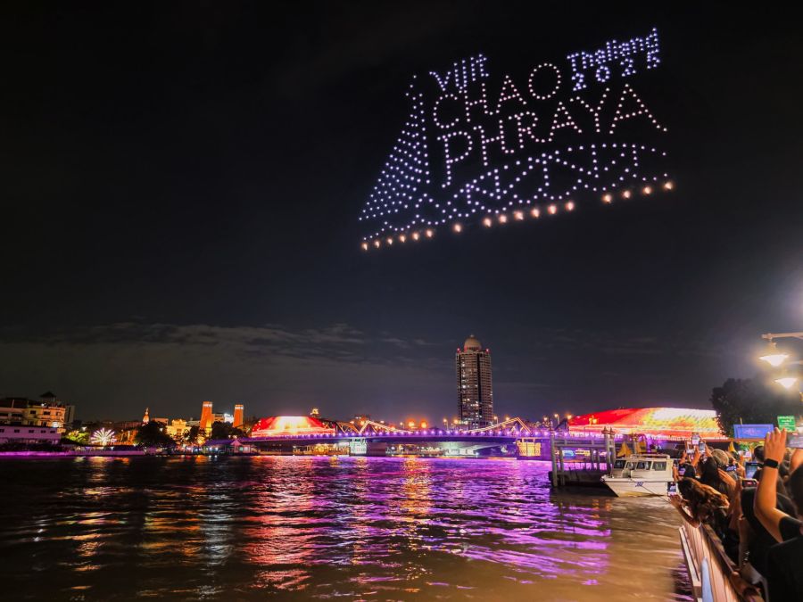 Spectacle de drones lumineux au-dessus d’une rivière nocturne