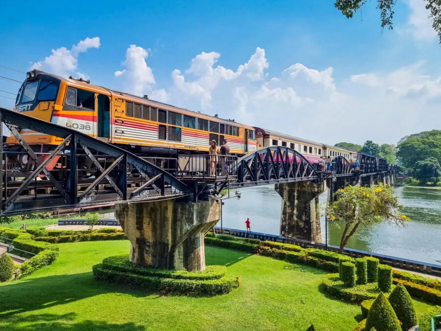 train passing over river kwai bridge in kanchanaburi